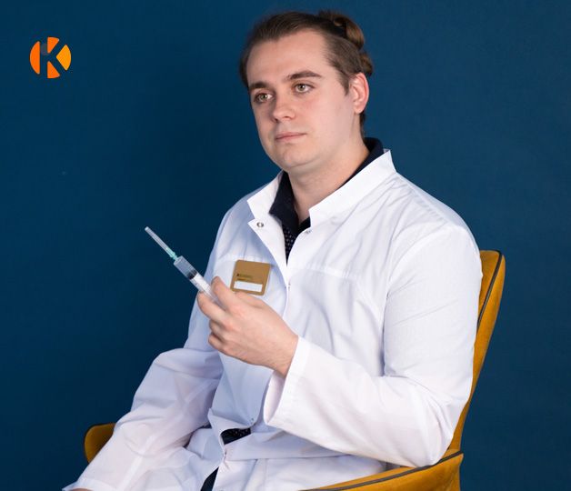 Врач держит в руке шприц